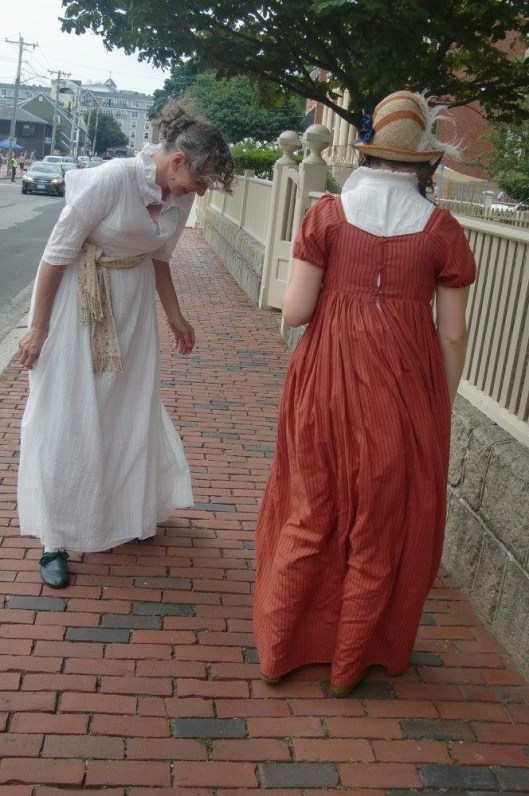 With Mrs B watching Miss B self-perambulate upon the sidewalk.